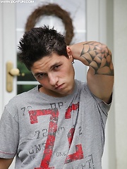 Tattooed stud Jeremy stroking his cock outdoors.